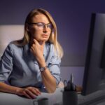 Medium shot woman working late at night on computer 